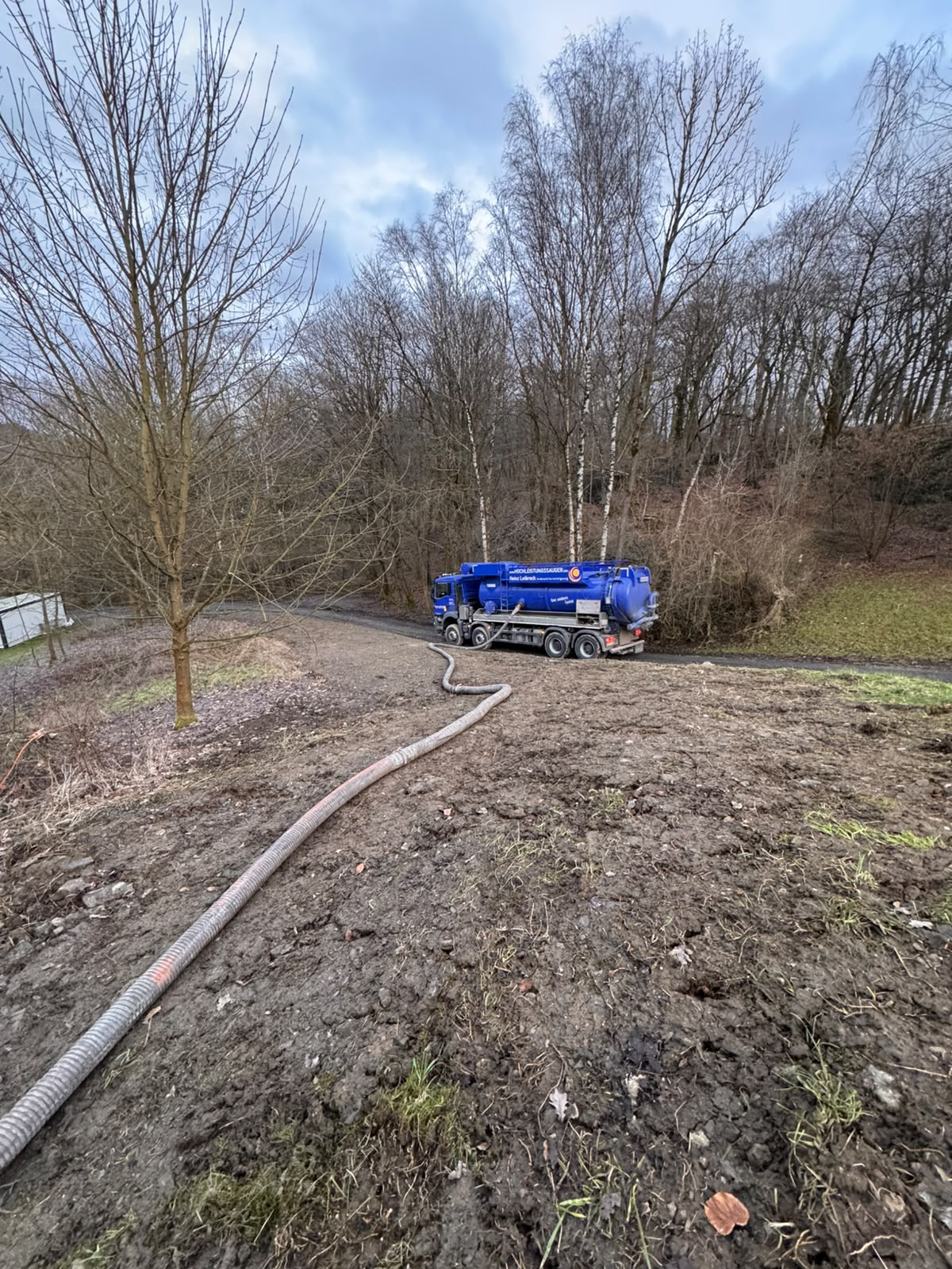 Langer Saugschlauch vom Fahrzeug über ein Feld